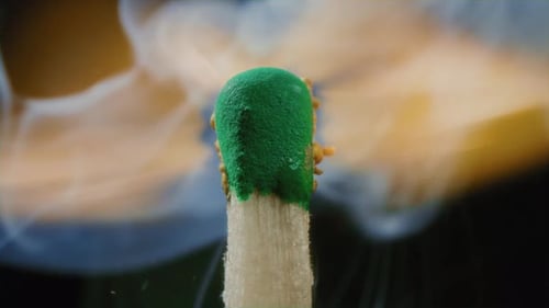 A Match Stick with a Green Sulfur Head Lights Up Slow Motion Macro Shot of Igniting Match