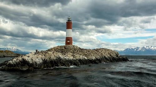 Roter und weißer Leuchtturm auf Felseninsel unter Dramatisch Himmel