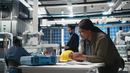Black Engineering Expert Checking Data on Papers at the Solar Energy Factory