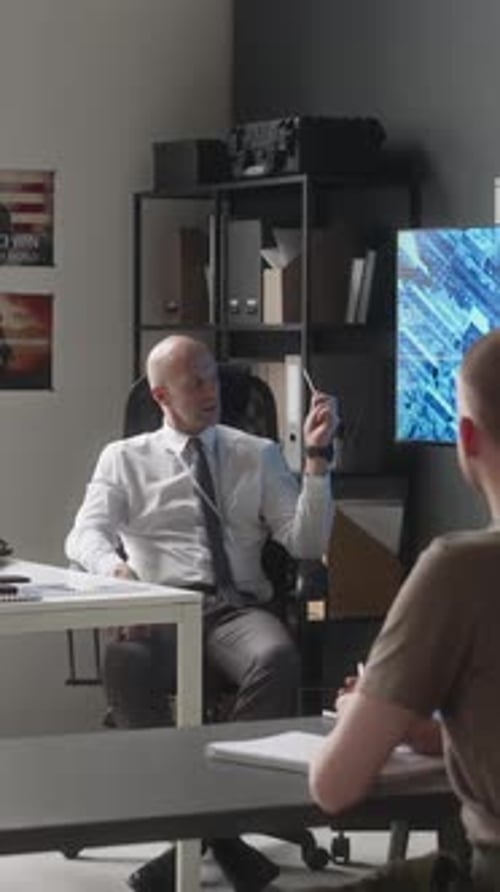 Man in Shirt Talks at Office Desk