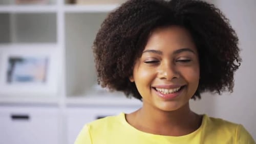 Smiling woman indoors with natural curly dark hair