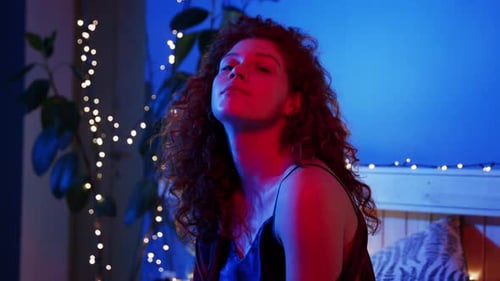 Woman with Red Hair Posing in Red and Blue Light