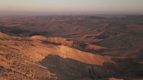 Aerial dolly exploring the Makhtesh Ramon Crater In Negev Desert at sunset, Israel.
