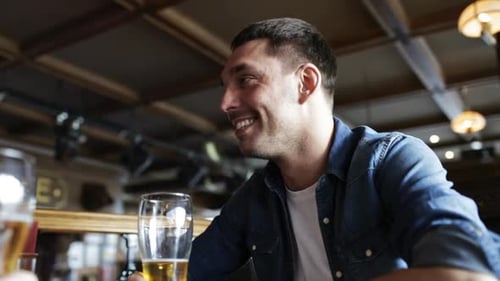 Man smiling at bar holding glass of beer