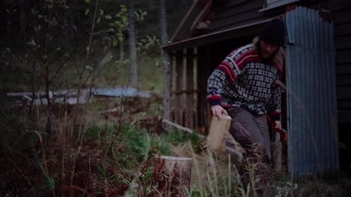 European Man Chopping Firewood With Axe In Trondelag, Norway. static shot