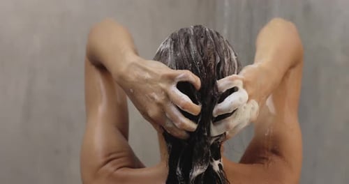 Back View of Naked Woman Washing Hair With Shampoo While Taking a Shower