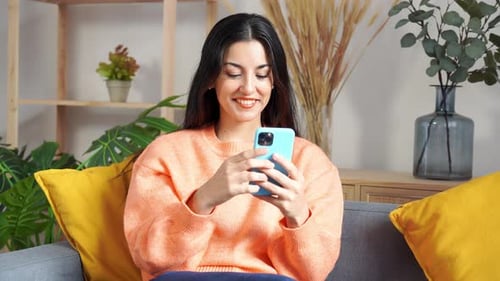 Woman Using Smartphone While Relaxing on Couch