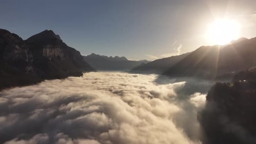 Aerial - sunlit mist over Walensee surrounded by Swiss mountains
