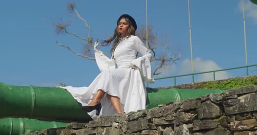 A girl wearing a vintage-style wedding dress exploring the corridors of an old fort.