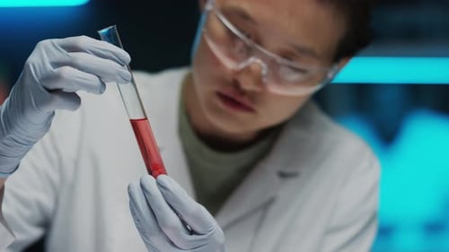 Lab Worker Holding Vial With Red Liquid
