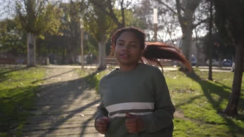 Woman Jogging in Park on Sunny Day