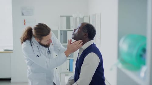 Doctor Examines Patient's Neck in Doctor's Office