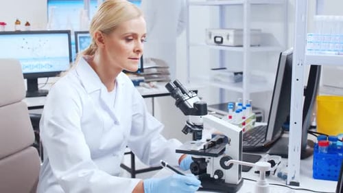 Female Scientist Working with Microscope in Laboratory