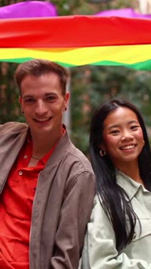 Smiling Friends Posing with Pride Flag in Urban Setting
