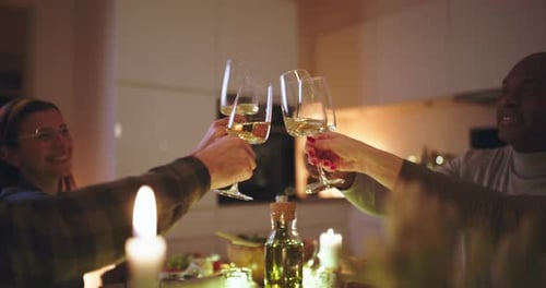Friends sharing toast at candlelit dinner party