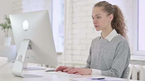Young Woman Shocked While Using a Desktop Computer