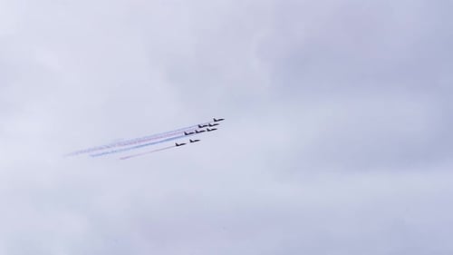 Squadron of Fighter Jets Soaring Through Cloudy Sky