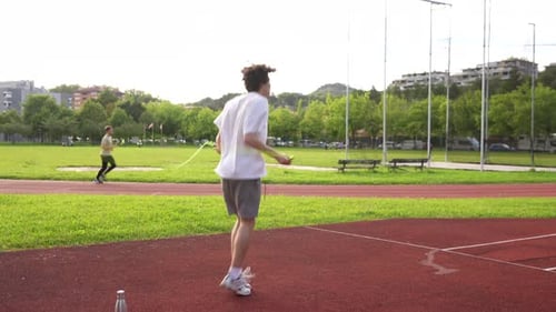 Young Adult Skipping Rope Outdoors on Track