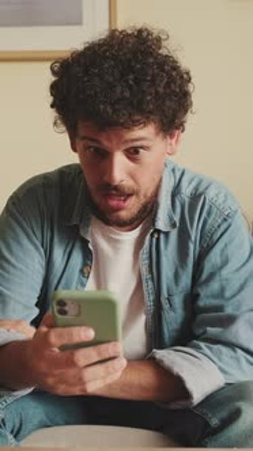 Surprised Man Using Smartphone Indoors