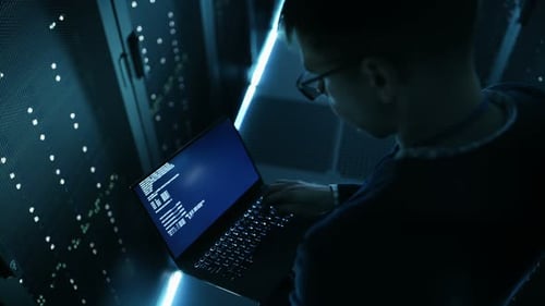 Captura desde un ángulo alto de un especialista en TI sujetando un cuaderno y trabajando en él. Es empleado de Big Ultramod