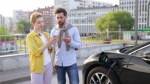 Couple Charging Electric Vehicle