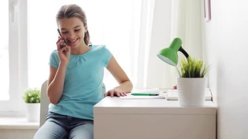 Teen Girl Chatting on Mobile Phone at Desk