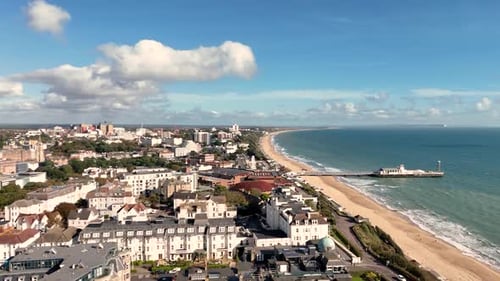 Bournemouth, vuelo a lo largo del paseo marítimo sobre el centro de conferencias, la ciudad y la playa hacia