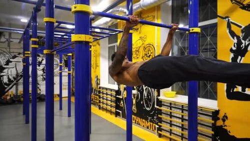 Young African Sportsman Showing Some Gymnastics Stunts on Horizontal Bar at Sport Club Muscular Afro