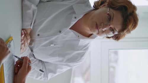 Woman Sitting Doctor Cabinet Filling Medical Form Agreement Vertical Close Up