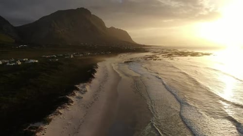 Golden Sunset Over Scenic Coastal Mountains and Peaceful Ocean Waves