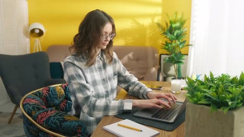 Woman Typing on Laptop Computer at Home