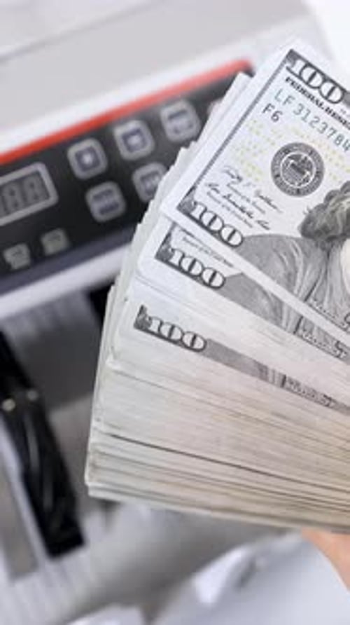 Bundle of one hundred dollar banknotes. Female's hands holding a large sum of money of dollar bills