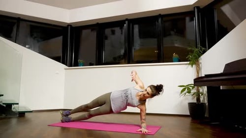 Woman Doing a Side Plank with Arm Raise