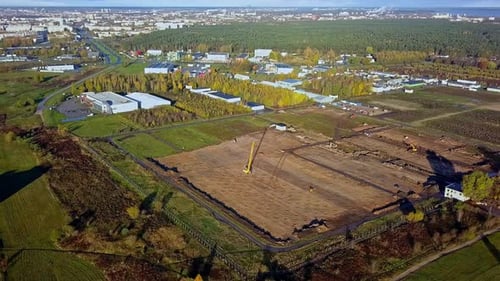 Vista panorámica aérea de una gran parcela de terreno con una grúa para la construcción de edificios