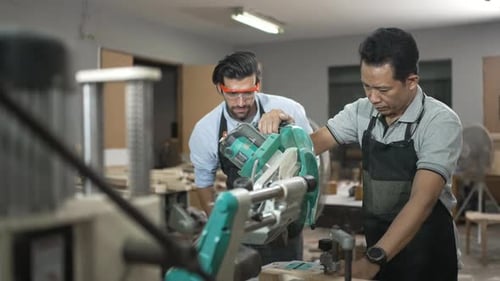 Carpenters are working together at workshop.