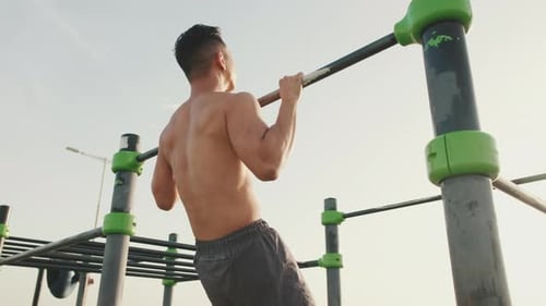 Shirtless Man Doing Pull-ups at Outdoor Gym