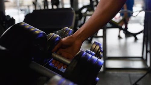 Close Up of African American Man Takes Dumbbell in Gym