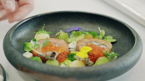 Chef Plates Elegant Salmon Dish with Edible Flowers