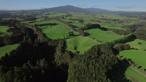 Drone shot over rolling hills of forest and farmland.
