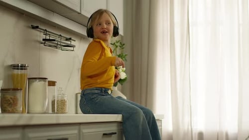 Caucasian Active Happy Little Girl Child Headphones Listening Music Dancing Jumping Off Table in