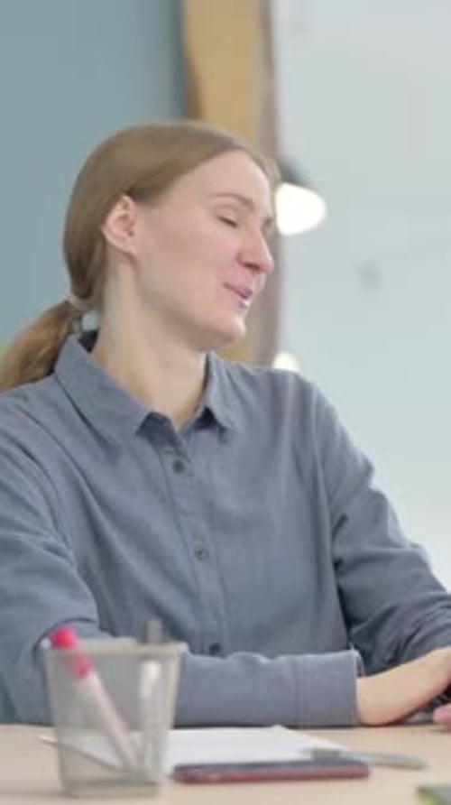 Woman at Desk Speaking During Meeting