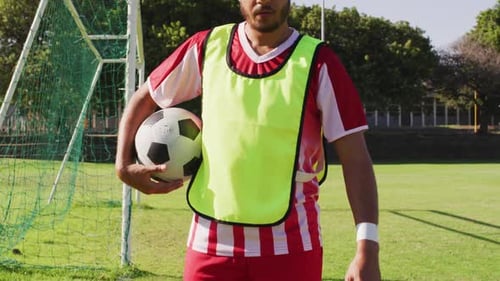 Video of biracial male football players with ball on field