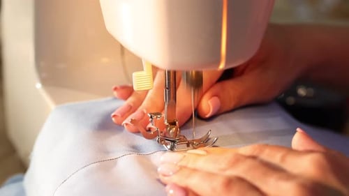 Woman working with sewing machine, closeup view