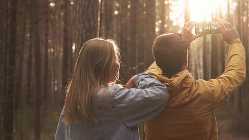 Couple Making Selfie At Smartphone At Background Of Sunny Green Forest. Hiking Emotionally Concep...