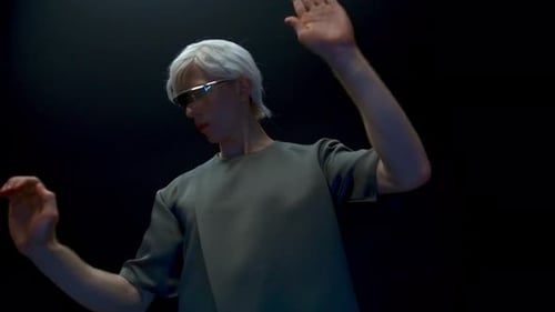 Man with White Hair Gesturing in Dark Studio