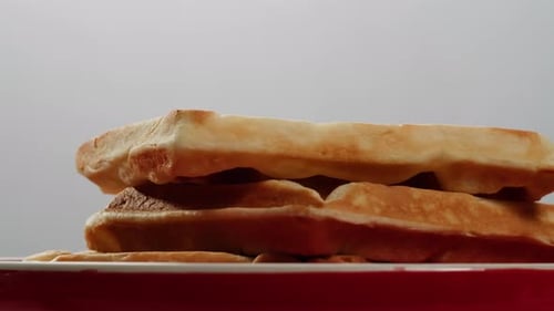 Belgian Waffles Sprinkled with Powdered Sugar with Condensed Milk Top View on a White Background