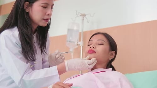 A doctor injects Botox into a patient's face at beauty clinic.