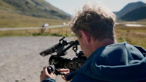 Man Filming Outdoors with Professional Video Camera
