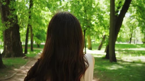 the Head of a Woman with Black Long Hair Who Walks Along the Street of Her City