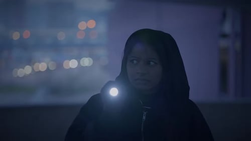 Young Woman with Flashlight Searching at Night